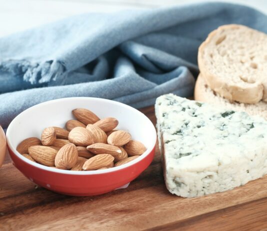 근육 회복을 위한 음식과 보충제, 운동 후 영양 회복 a bowl of almonds, bread, and an egg on a cutting board