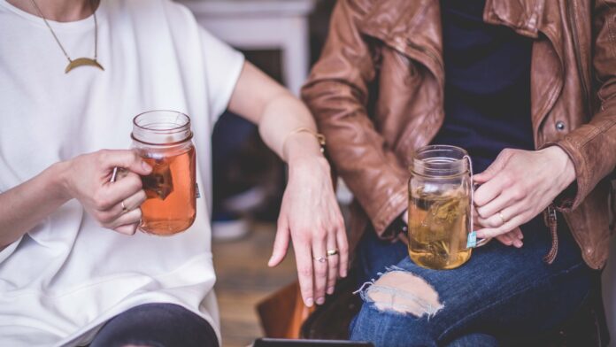 Photo by Matthew Henry two person sitting while holding clear glass mason mugs