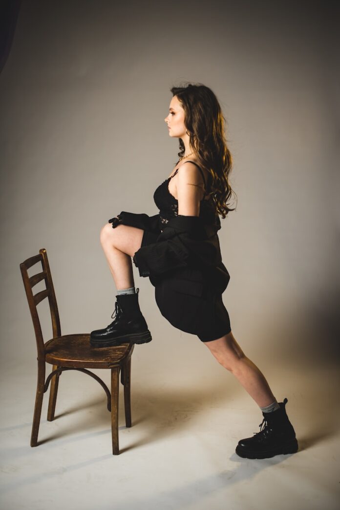 Photo by Kateryna Hliznitsova woman in black dress sitting on brown wooden chair