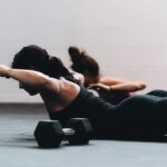 필라테스, 바쁜 일상 속 몸과 마음을 다잡는 생활운동으로 주목 woman in black tank top and black leggings lying on black floor