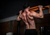 우리 몸의 엔진, 근육을 지키는 일상 루틴의 변화 topless man in black shorts holding orange bar