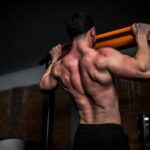 우리 몸의 엔진, 근육을 지키는 일상 루틴의 변화 topless man in black shorts holding orange bar
