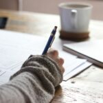 바쁜 일상 속, 내 마음을 지키는 ‘마이크로 멘탈 케어’가 뜬다 person writing on brown wooden table near white ceramic mug