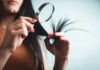 자연스러운 윤기로, 최신 헤어 건강 트렌드와 일상 실천법 Woman examining split ends of hair with magnifying glass