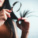 자연스러운 윤기로, 최신 헤어 건강 트렌드와 일상 실천법 Woman examining split ends of hair with magnifying glass