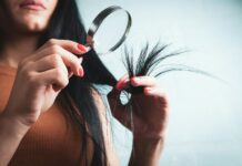 자연스러운 윤기로, 최신 헤어 건강 트렌드와 일상 실천법 Woman examining split ends of hair with magnifying glass