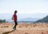 일상 속 걷기 루틴, 건강을 지키는 가장 손쉬운 습관 a man with a backpack walking across a dry grass covered field