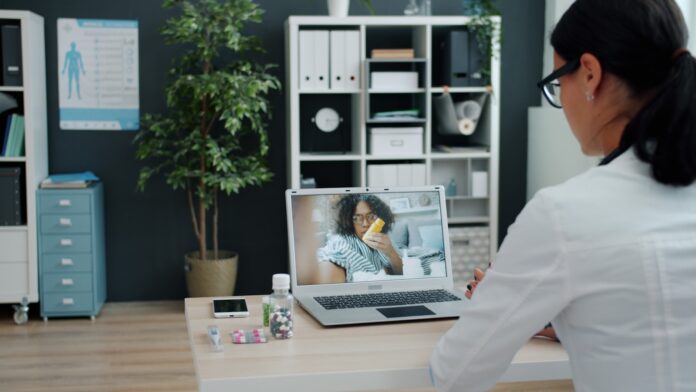 Photo by Vitaly Gariev Doctor consulting patient via video call on laptop